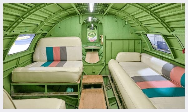A green airplane with two beds and one bed in it.