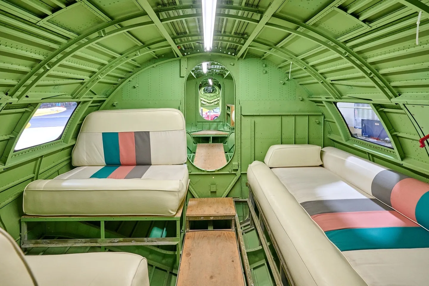A green airplane with two beds in it.