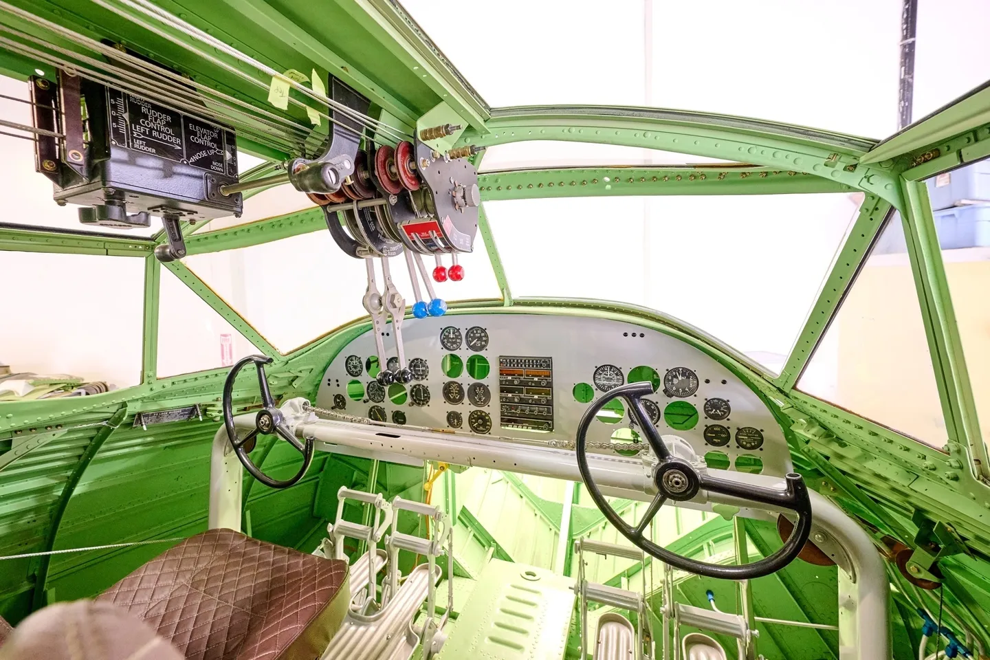 A green airplane cockpit with controls and switches.
